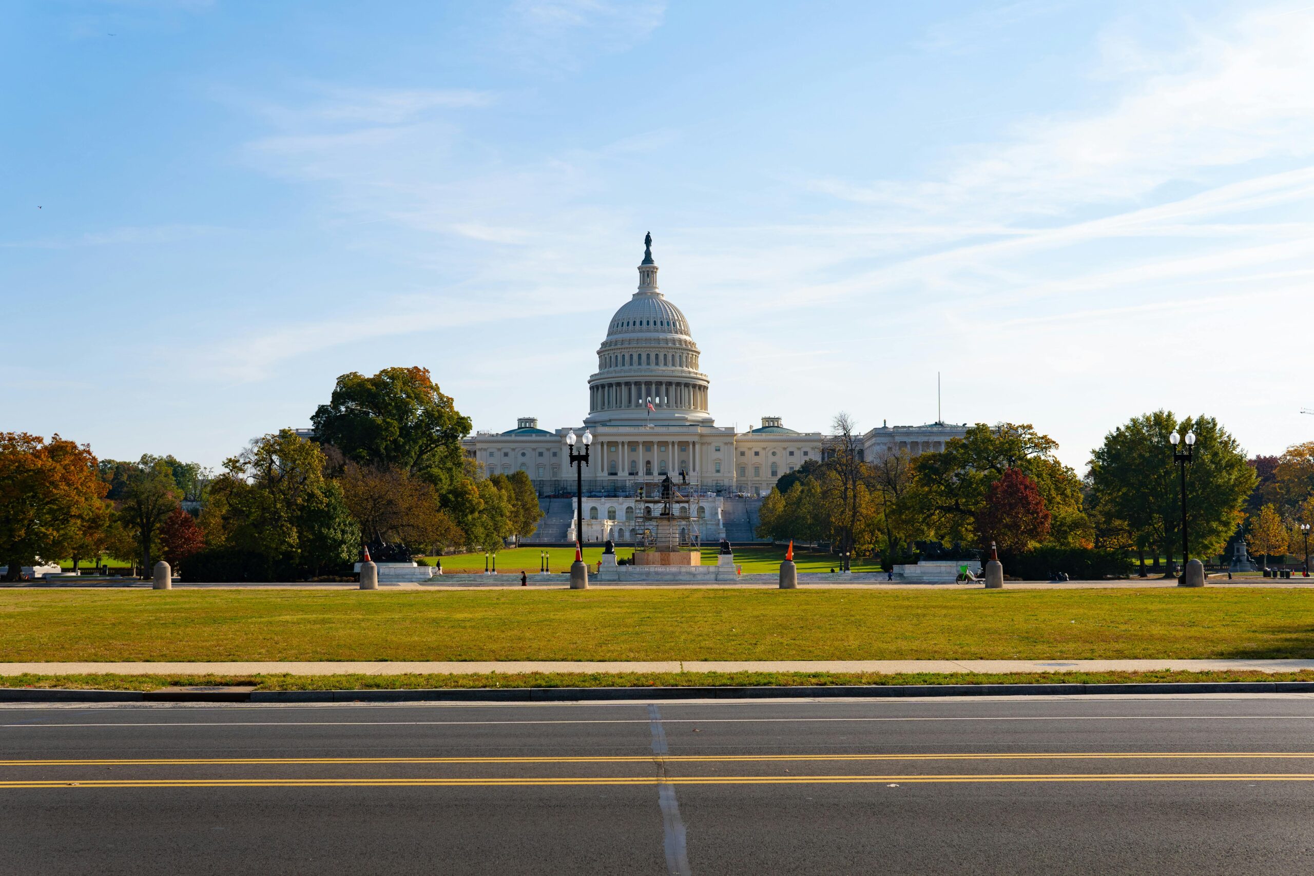 A stunning summer view of the United States Capitol with clear skies and greenery.
